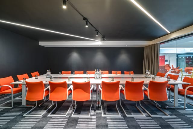 Modern conference room with vibrant orange chairs for collaborative meetings in Bathwick.