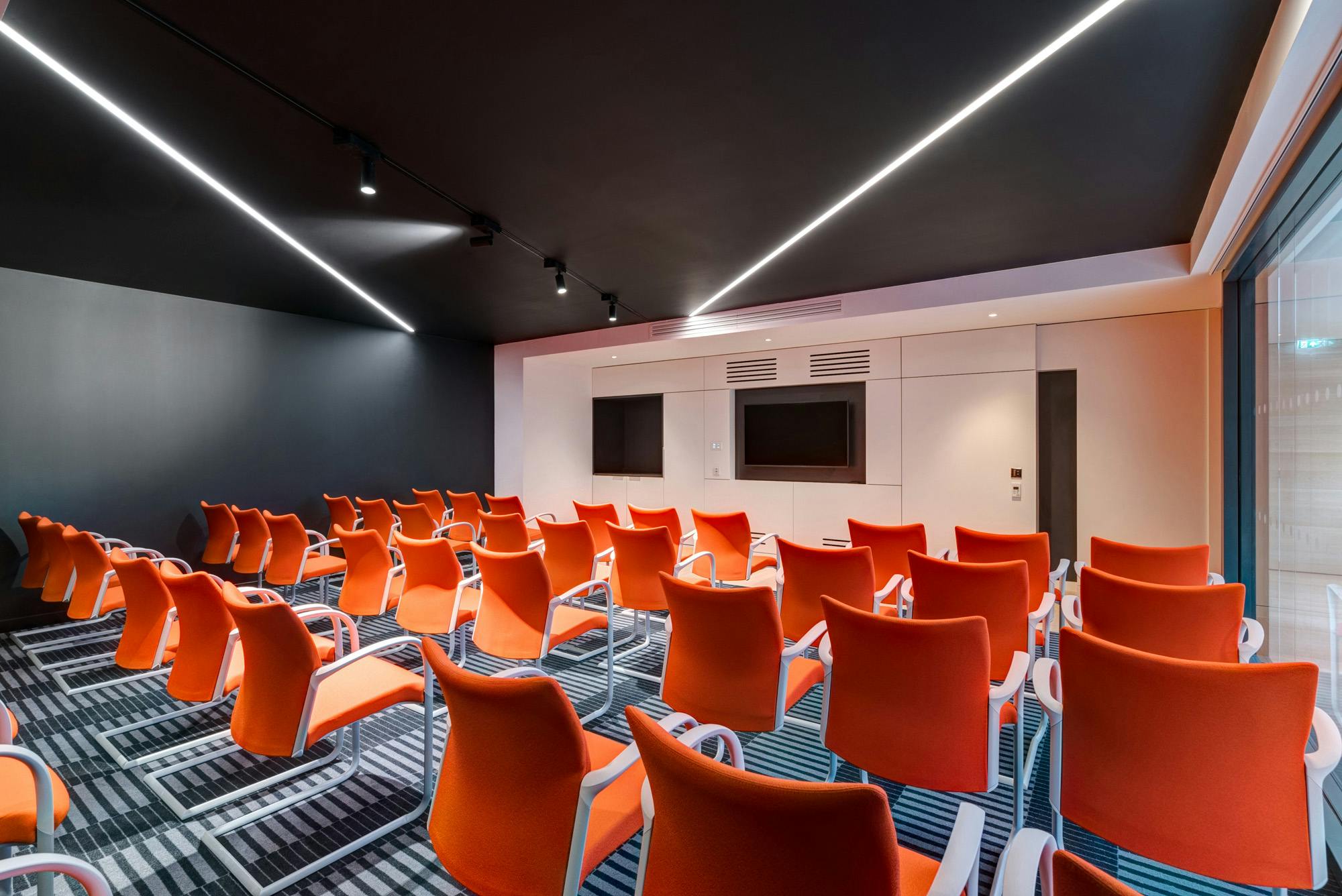 Modern meeting room at Apex City of Bath Hotel with vibrant orange chairs for workshops.