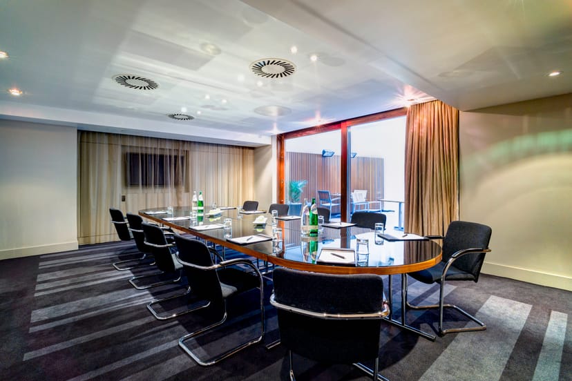 Modern meeting room in Apex City of London Hotel, featuring a sleek oval table.