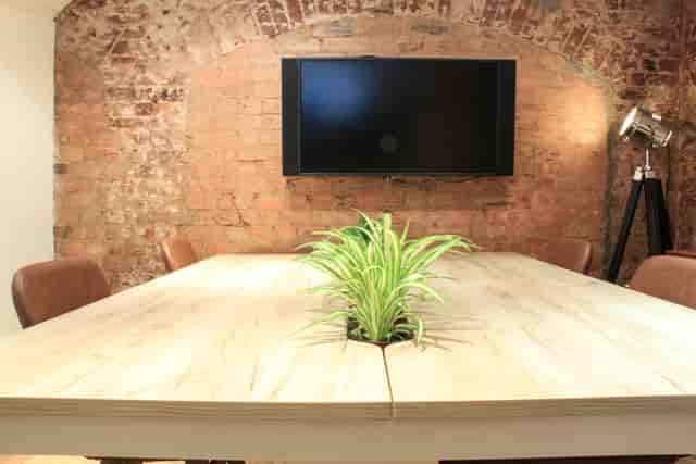 Modern meeting room with wooden table, ideal for presentations and gatherings.