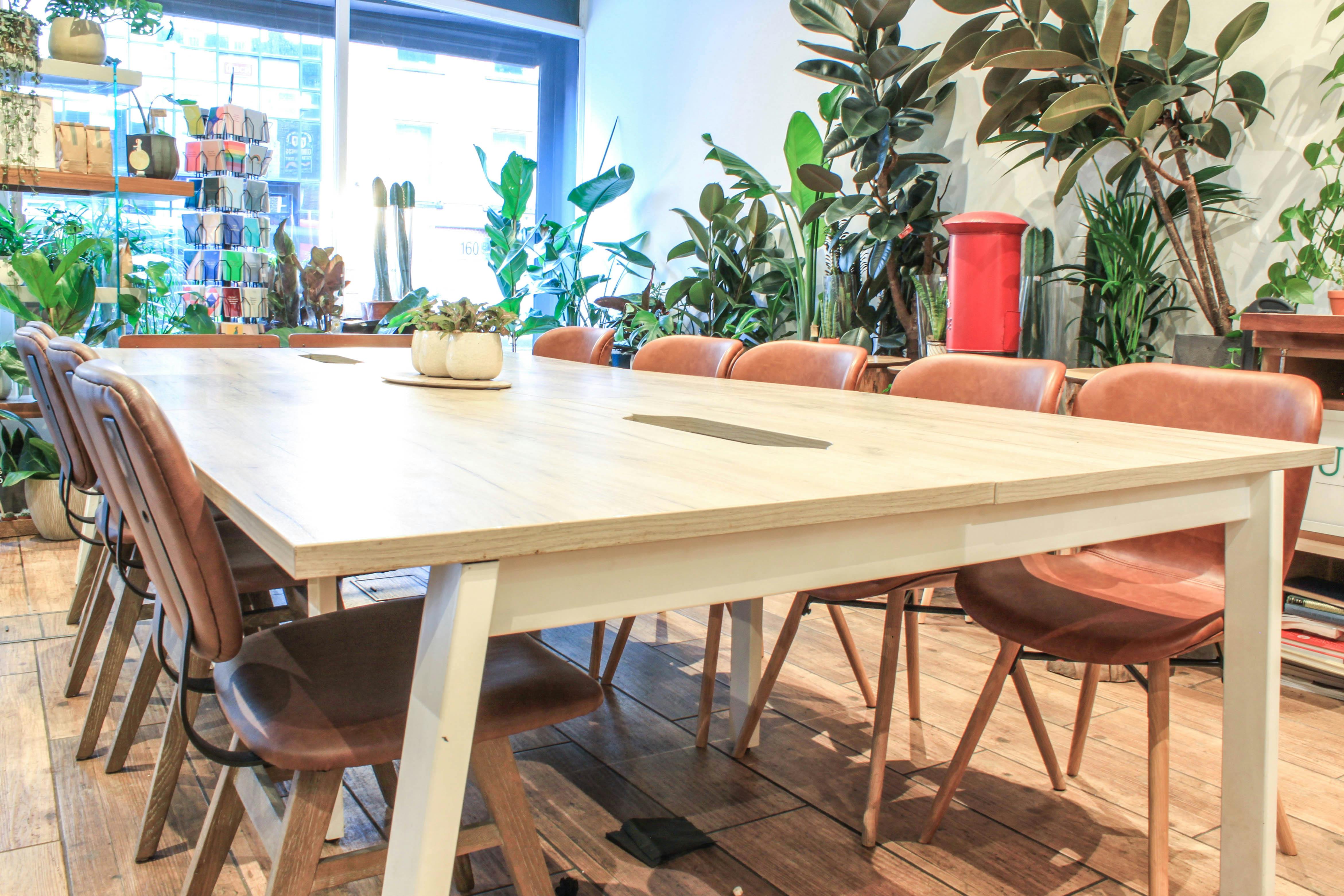 Modern meeting room with wooden table and leather chairs, perfect for workshops and team meetings.