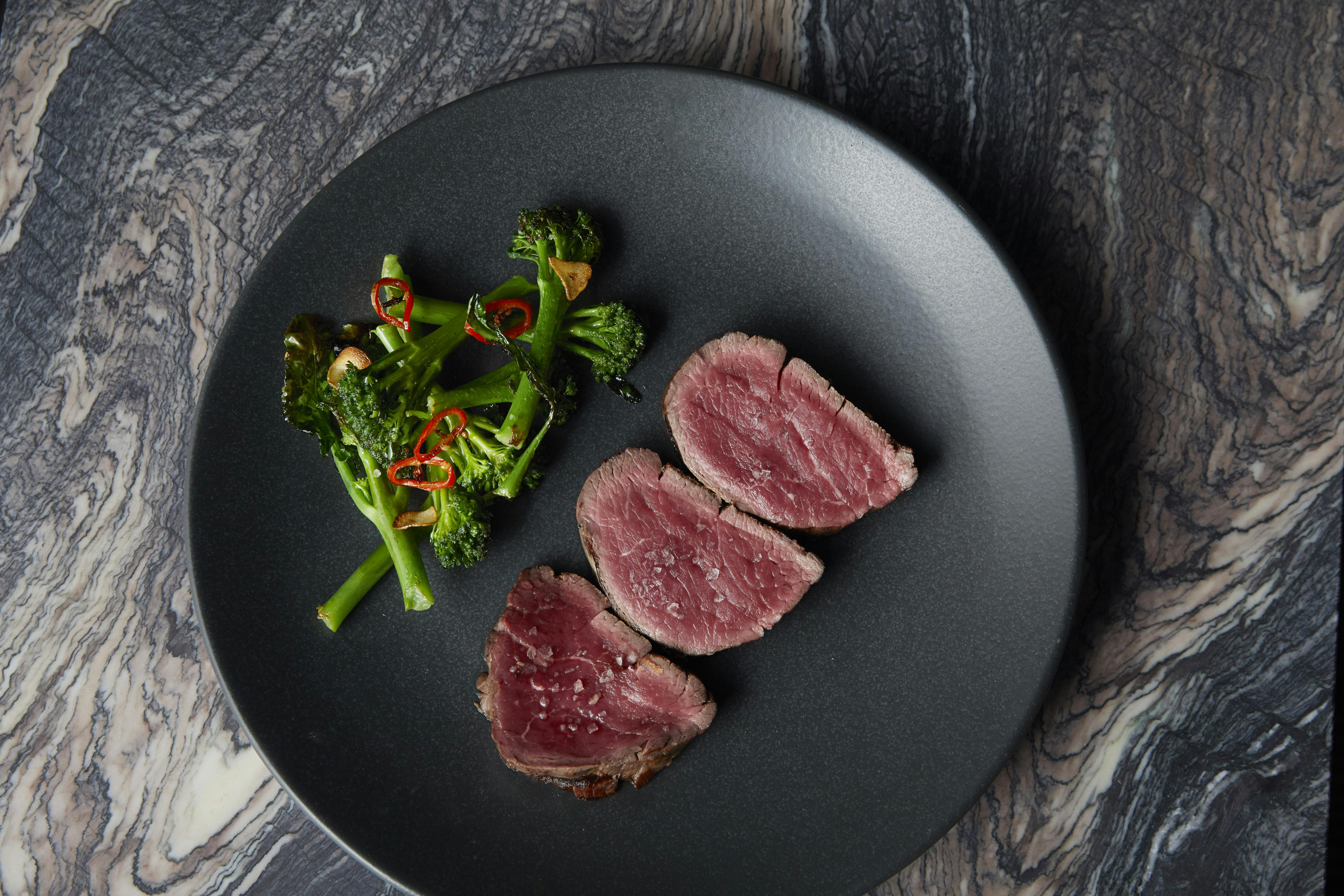 Semi-private dining room with elegant meat dish, perfect for events and meetings.