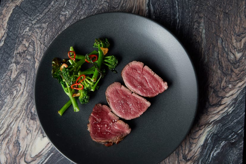 Semi-private dining room with elegant meat dish, perfect for events and meetings.