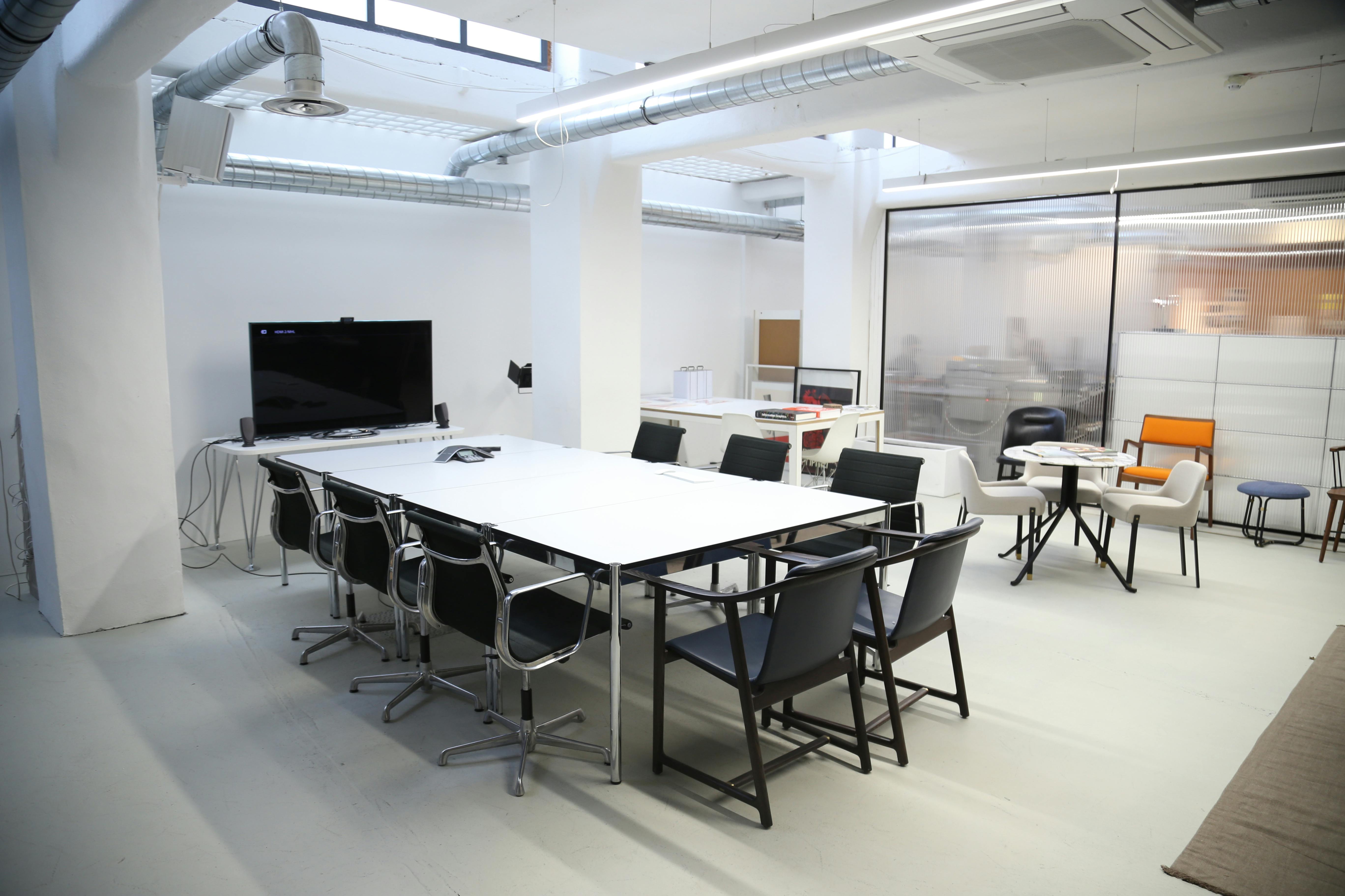 Modern meeting room with large white table, ideal for team meetings and brainstorming sessions.