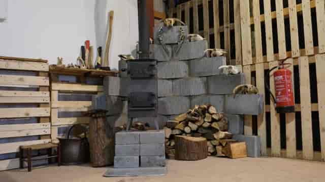 Rustic event space with wood-burning stove, perfect for intimate gatherings and workshops.