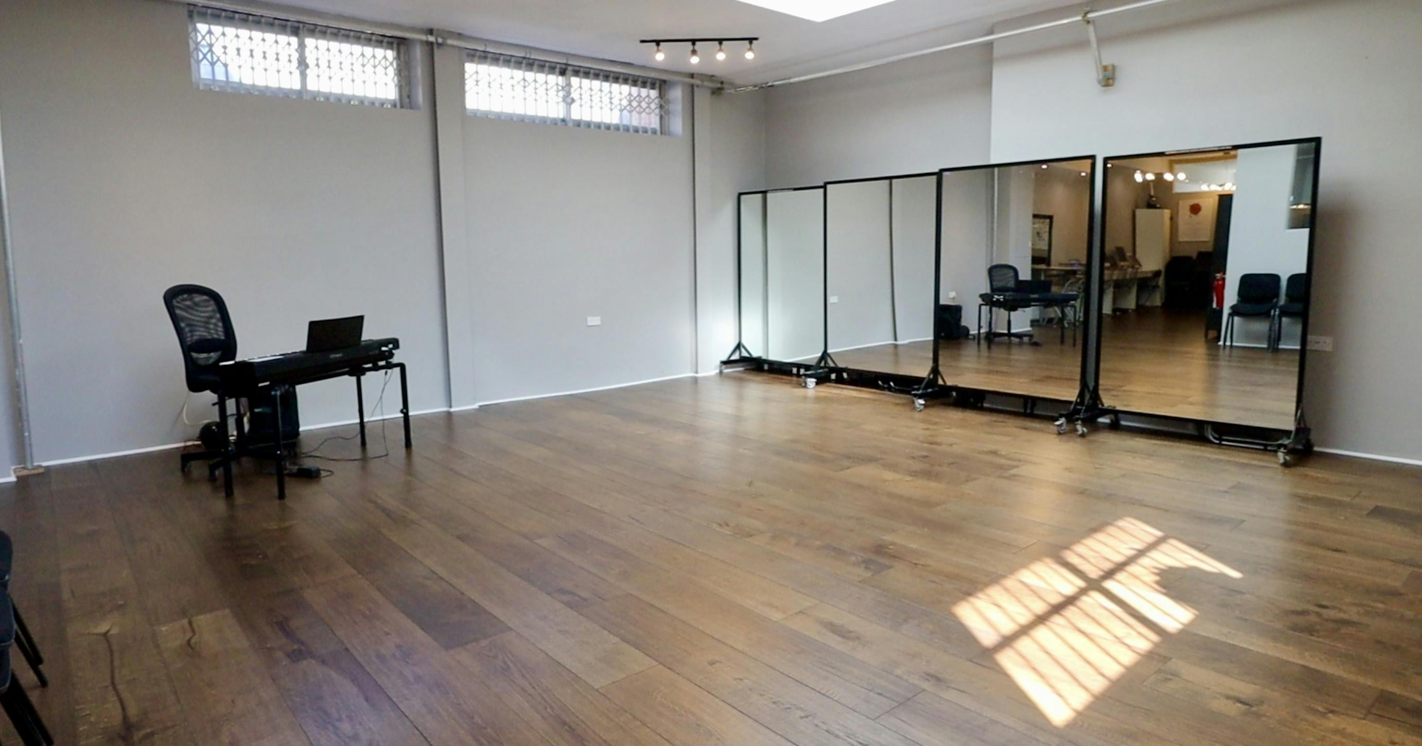 Ground floor studio with polished wooden floors for workshops and fitness classes.