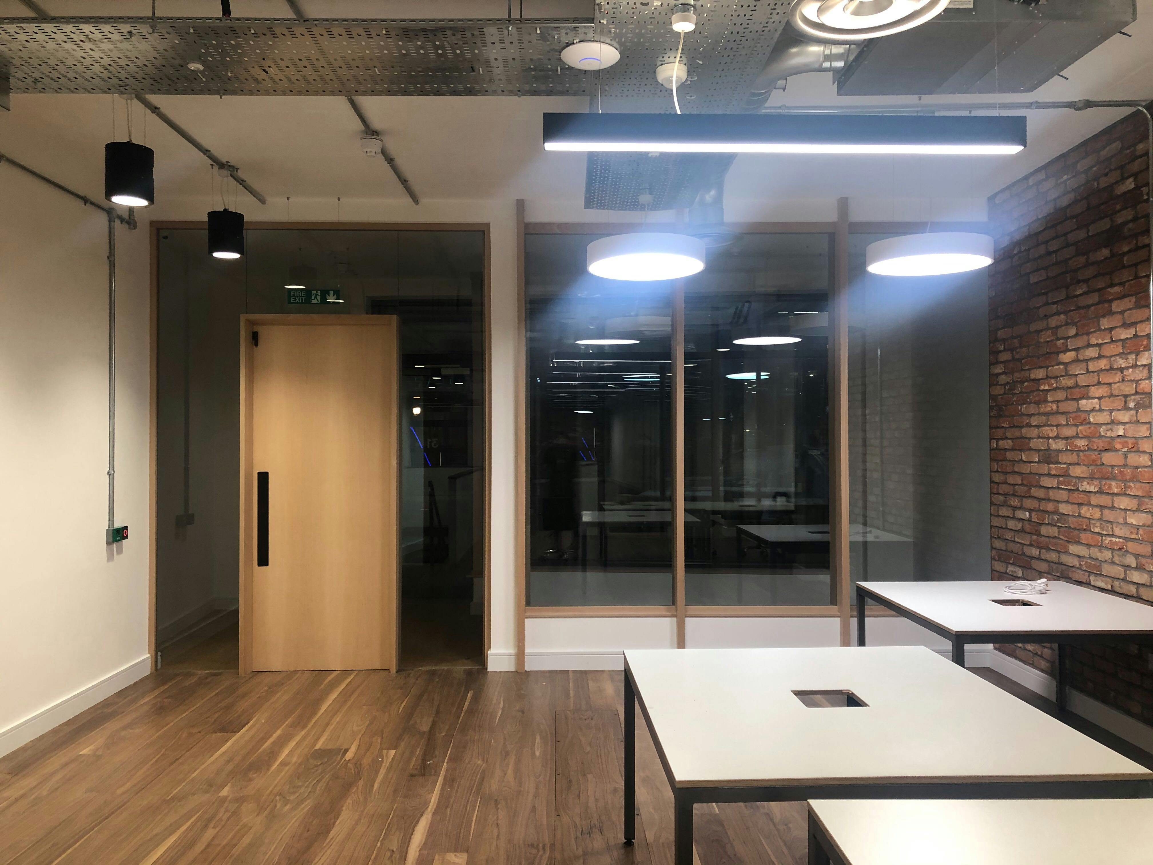 Modern meeting space with wooden flooring, ideal for workshops and collaborative sessions.