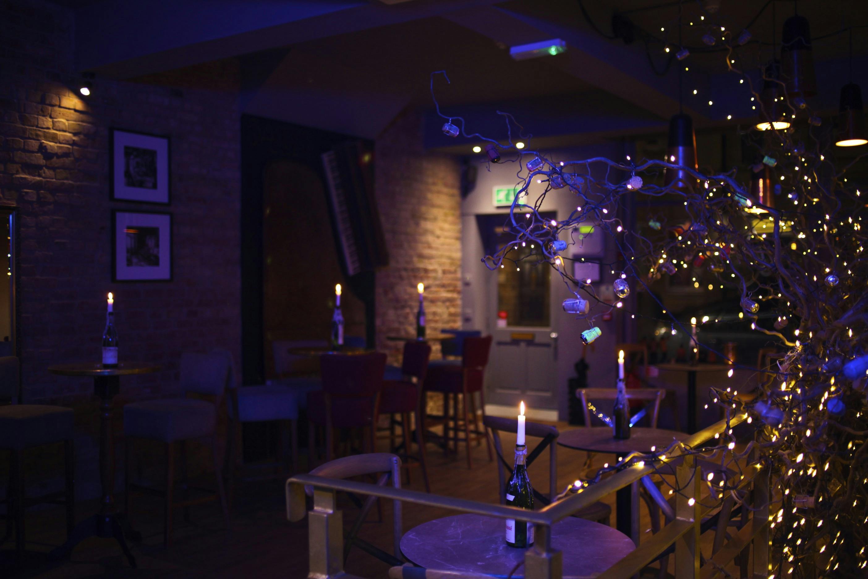 Cozy event space at Sandy's Piano Bar with soft lighting for holiday parties.