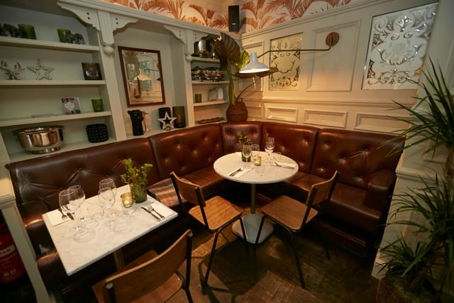 Cozy dining space with plush leather seating for private events and networking lunches.