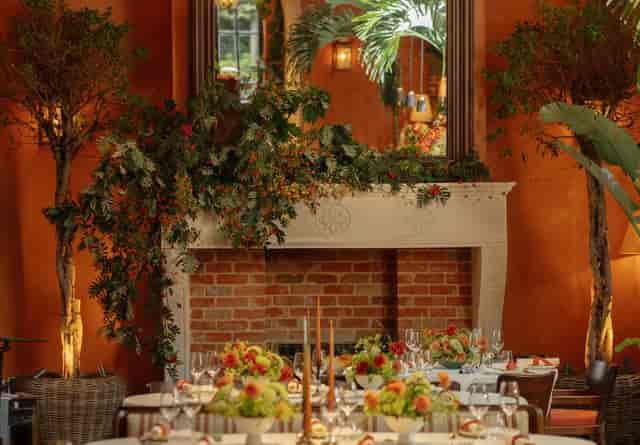 Luxury private dinner in Belvedere featuring a rustic brick hearth and lush floral installations.