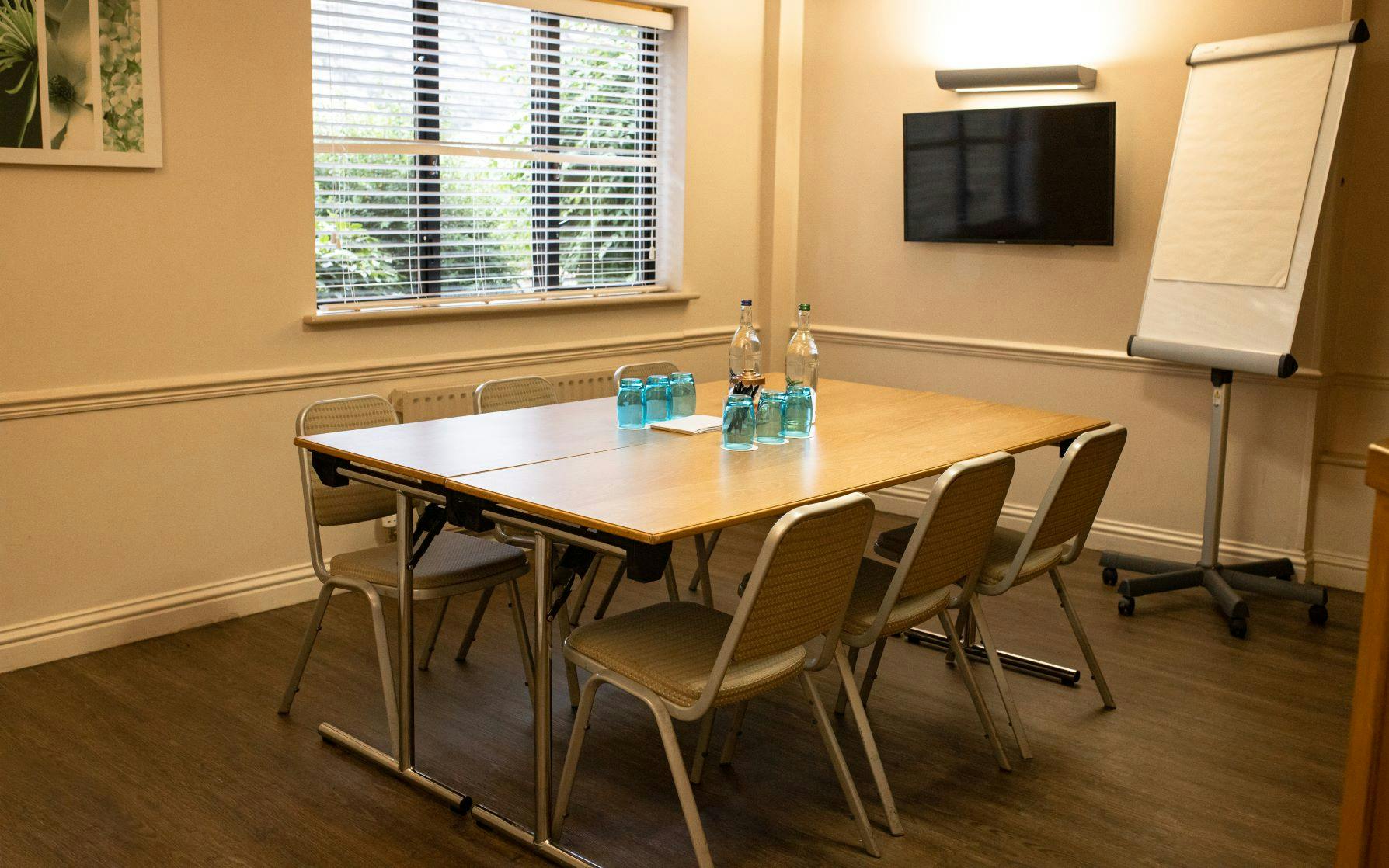 Meeting room at voco™ Oxford Thames Hotel with central table, ideal for workshops and presentations.