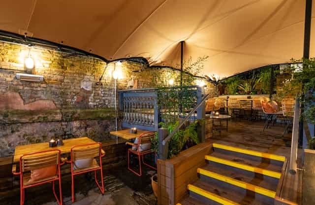 Charming outdoor event space with warm lighting for intimate gatherings and meetings.