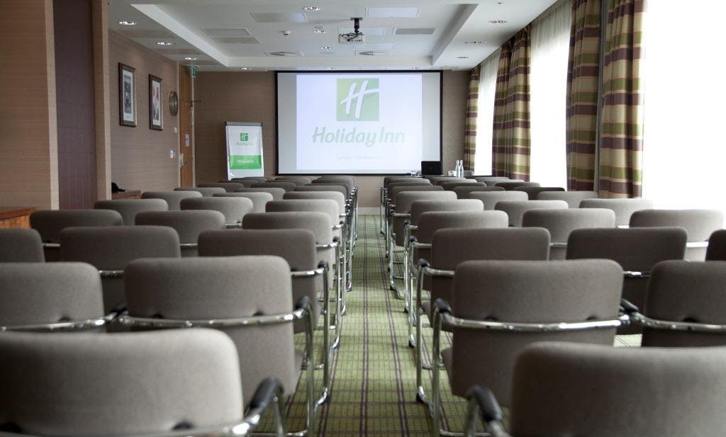 Corporate meeting room at Holiday Inn London Stratford City with large screen setup.