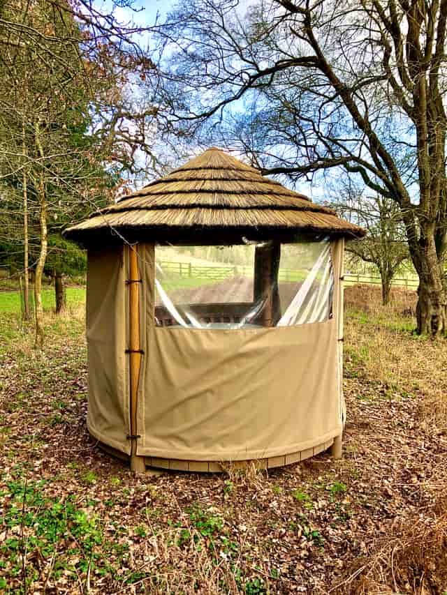 Woodland Lodge gazebo with thatched roof, perfect for outdoor retreats and gatherings.