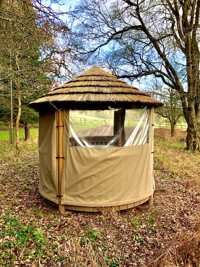 Woodland Lodge gazebo with thatched roof, perfect for outdoor retreats and gatherings.
