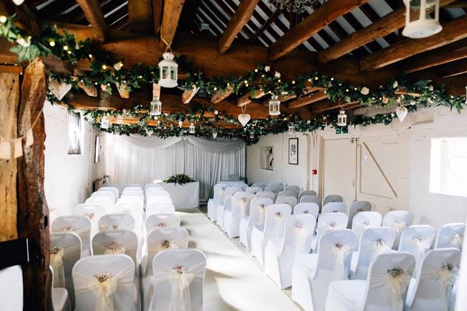 Elegant wedding venue with floral decor and rustic beams at The Surrey Barns.