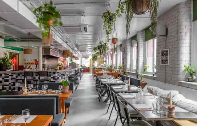 Modern restaurant venue with greenery, ideal for events and receptions at The Cotton Factory.