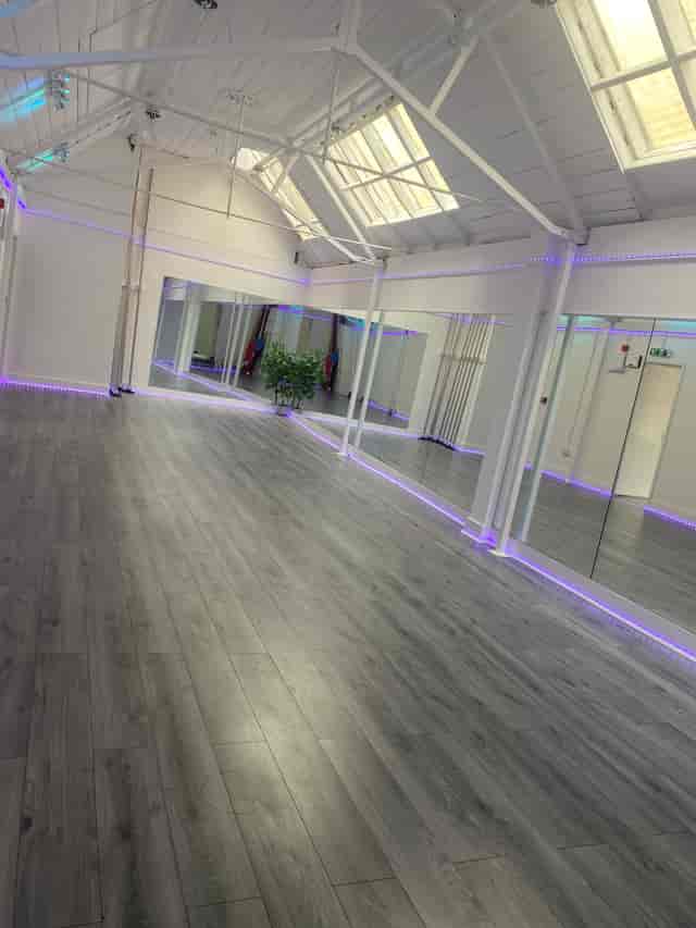 Versatile event space with modern flooring and mirrors, perfect for workshops and fitness classes.