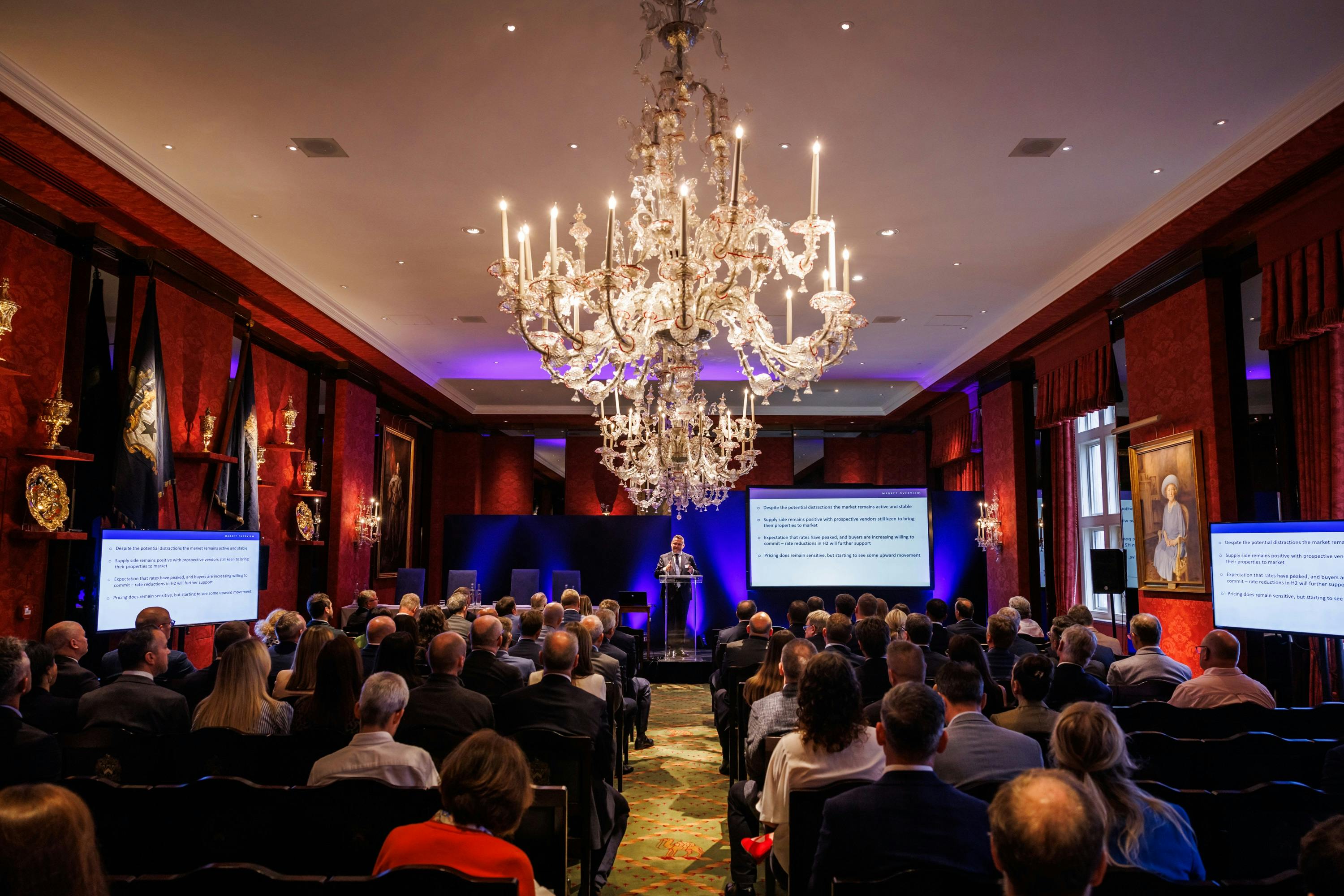 Livery Hall conference with elegant decor, speaker, and engaged attendees.