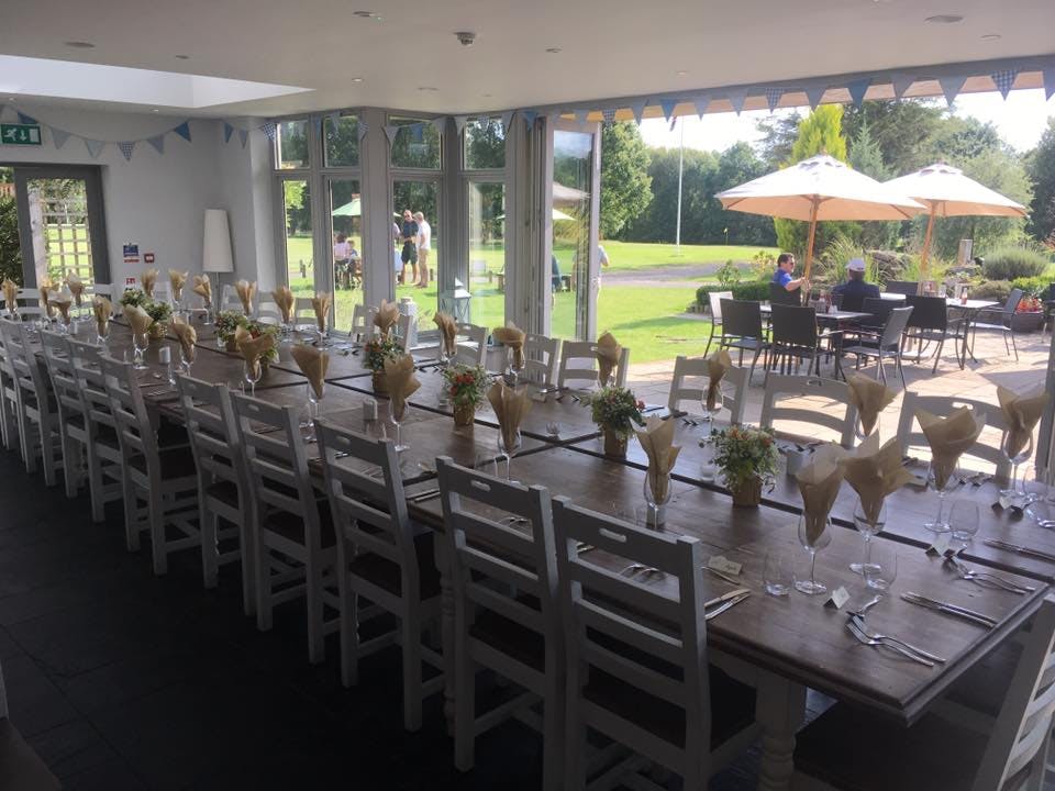 Elegant long table setup with floral centerpieces at Blacknest Golf Club for events.