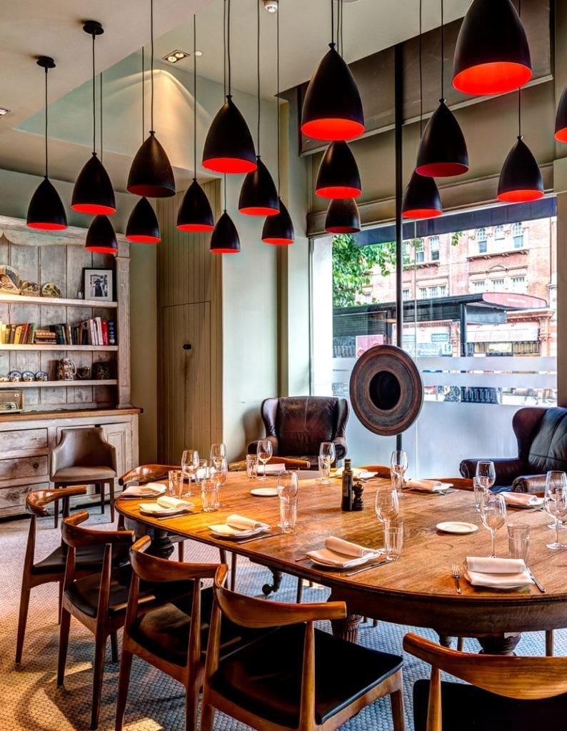 Semi-private dining room at TOZI Restaurant with round table, ideal for meetings and dinners.