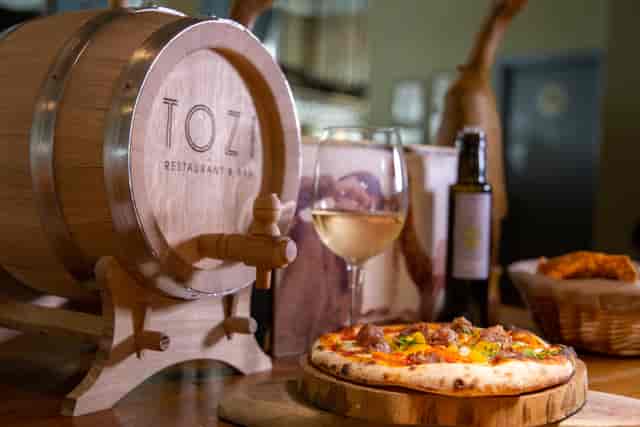Semi-private dining room at TOZI with rustic barrel, ideal for culinary events and gatherings.