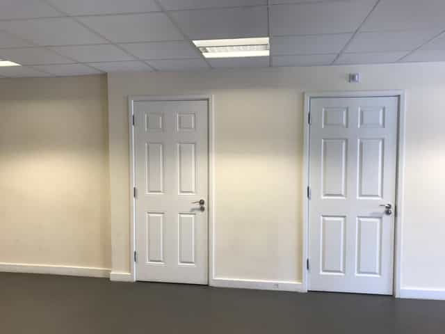 Main Hall in Savoy Court with blank wall and closed doors, perfect for versatile events.