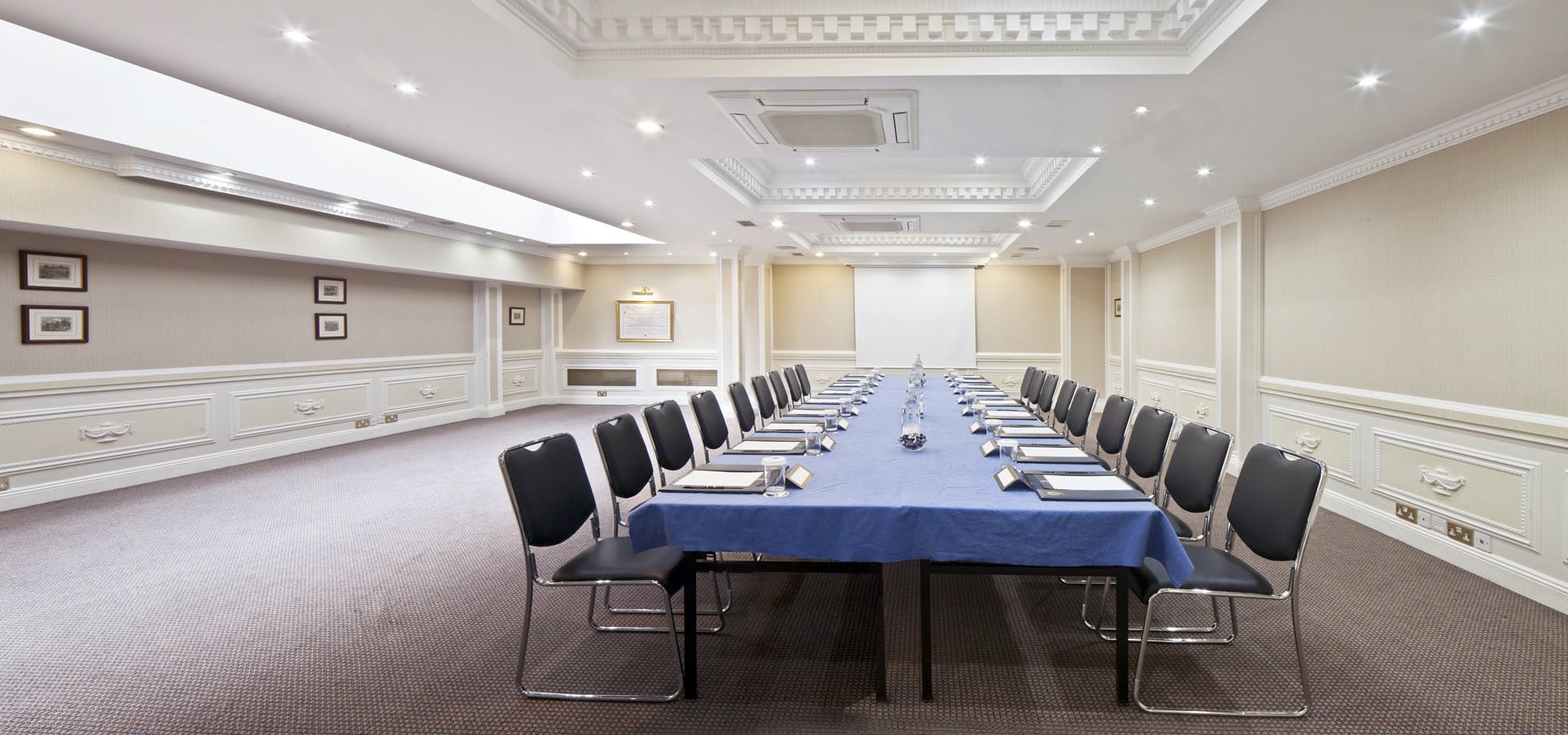 Portland Suite meeting room with blue tablecloth, ideal for professional gatherings and workshops.