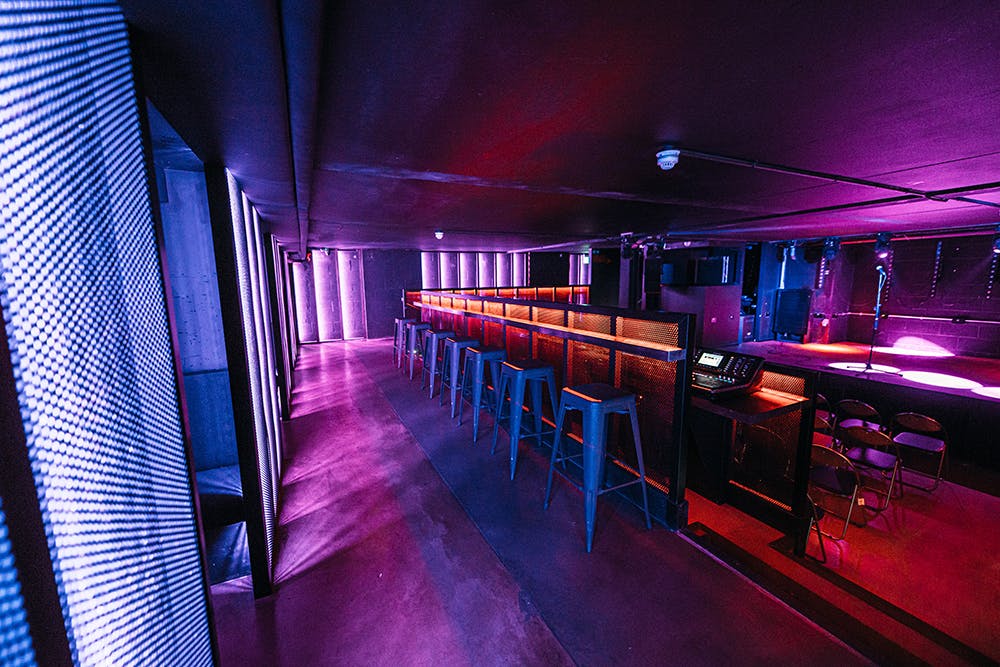 Modern event space in Peckham Audio with vibrant bar and ambient lighting.