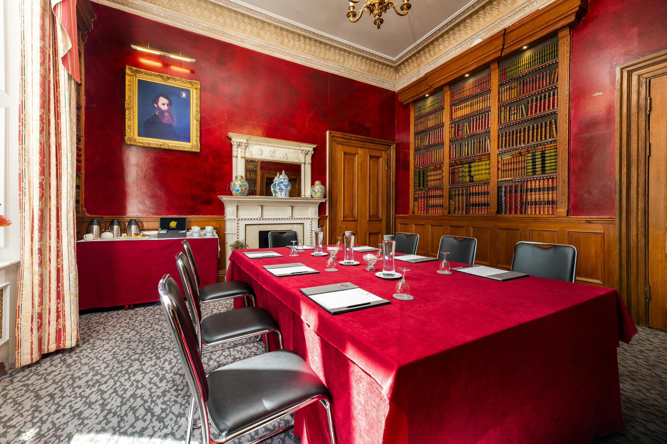 Sophisticated meeting room with red decor at Gem Strathmore Hotel for events and gatherings.