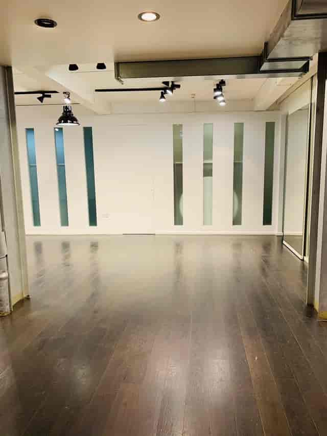 Versatile event space with polished wooden floor for corporate meetings and social gatherings.