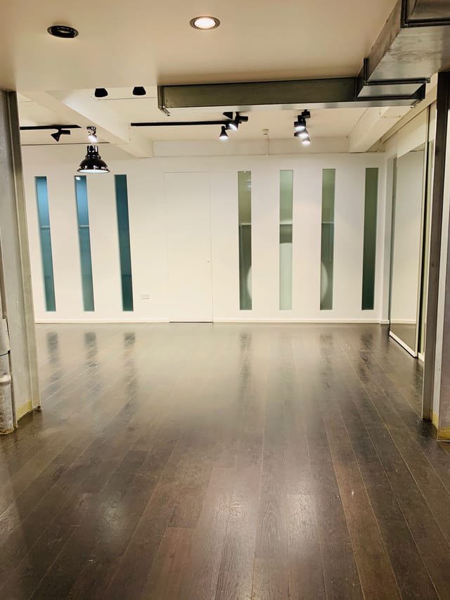 Versatile event space with polished wooden floor for corporate meetings and social gatherings.