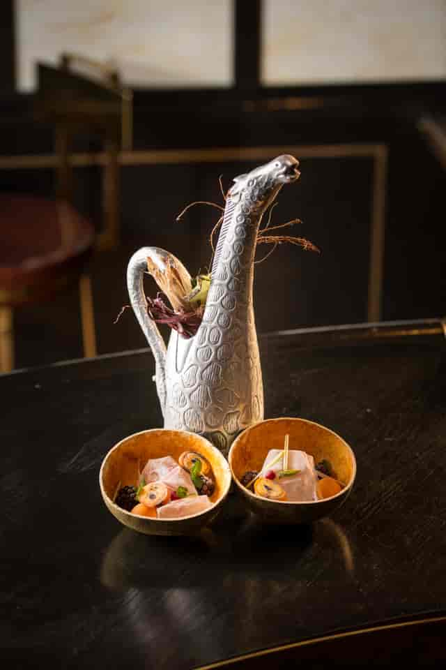 Artistic dish with silver pitcher and colorful food at Oriole Bar event venue.