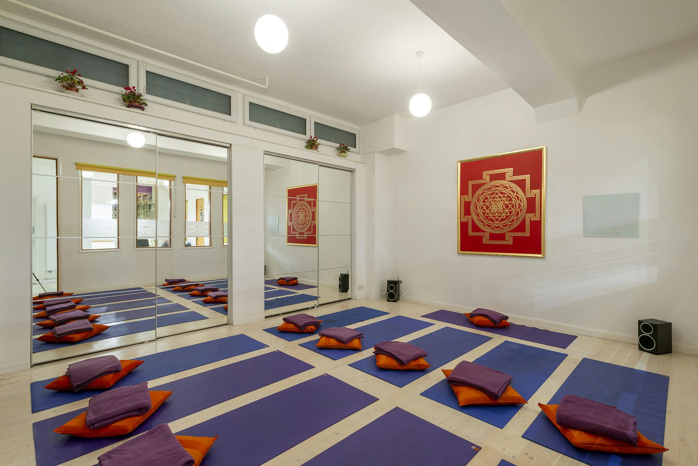 Serene Akshobia studio with mirrored walls, perfect for yoga workshops and meditation retreats.