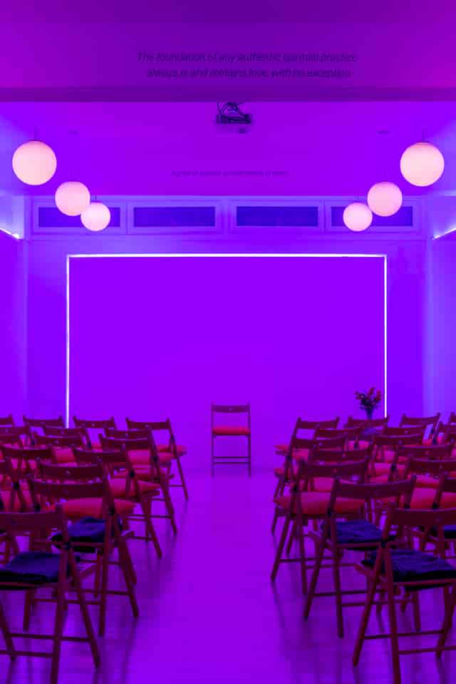 Modern event space at Hridaya Studio with purple lighting for workshops and presentations.
