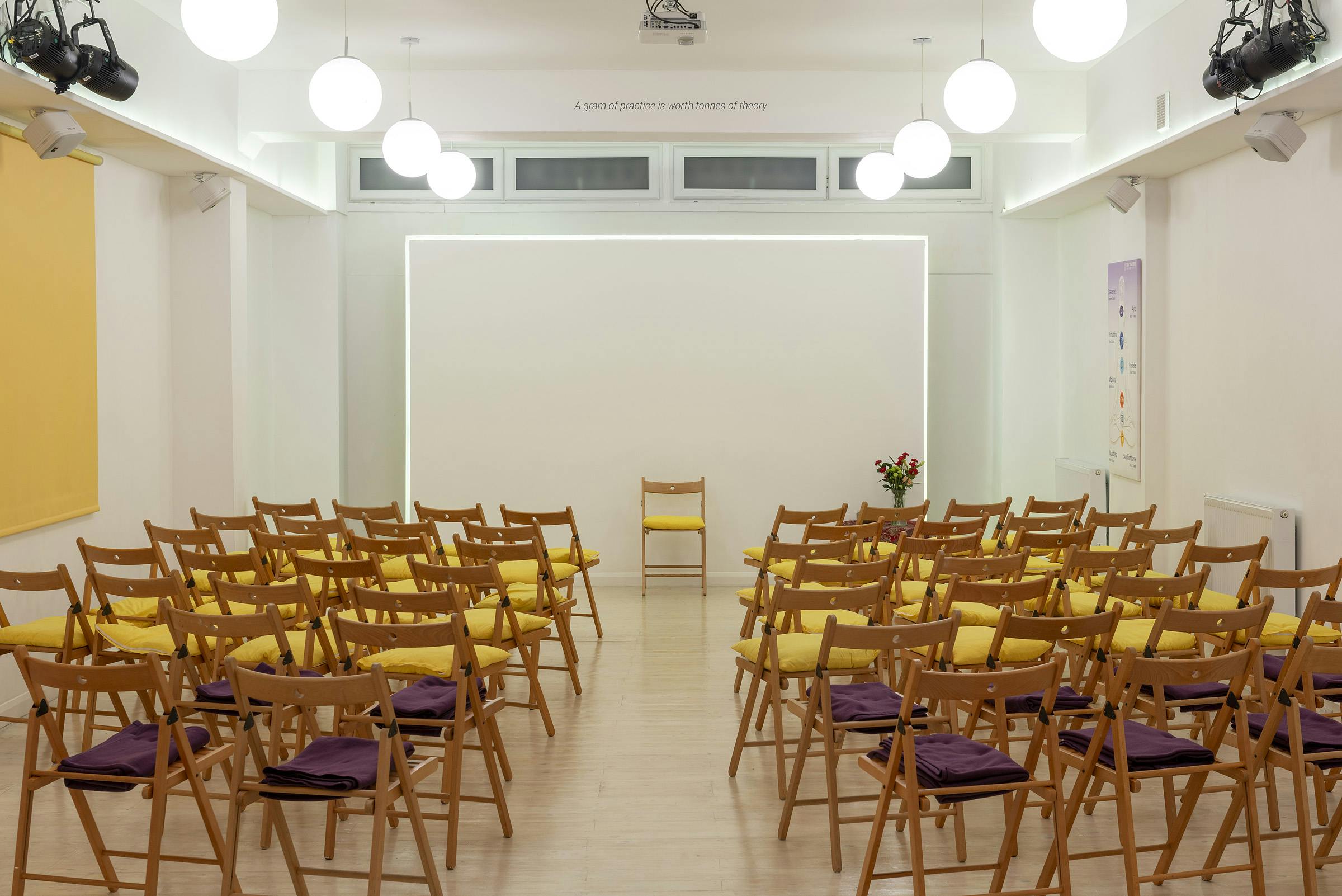 Hridaya Studio at Tara Yoga Centre, inviting workshop space with wooden chairs and cushions.