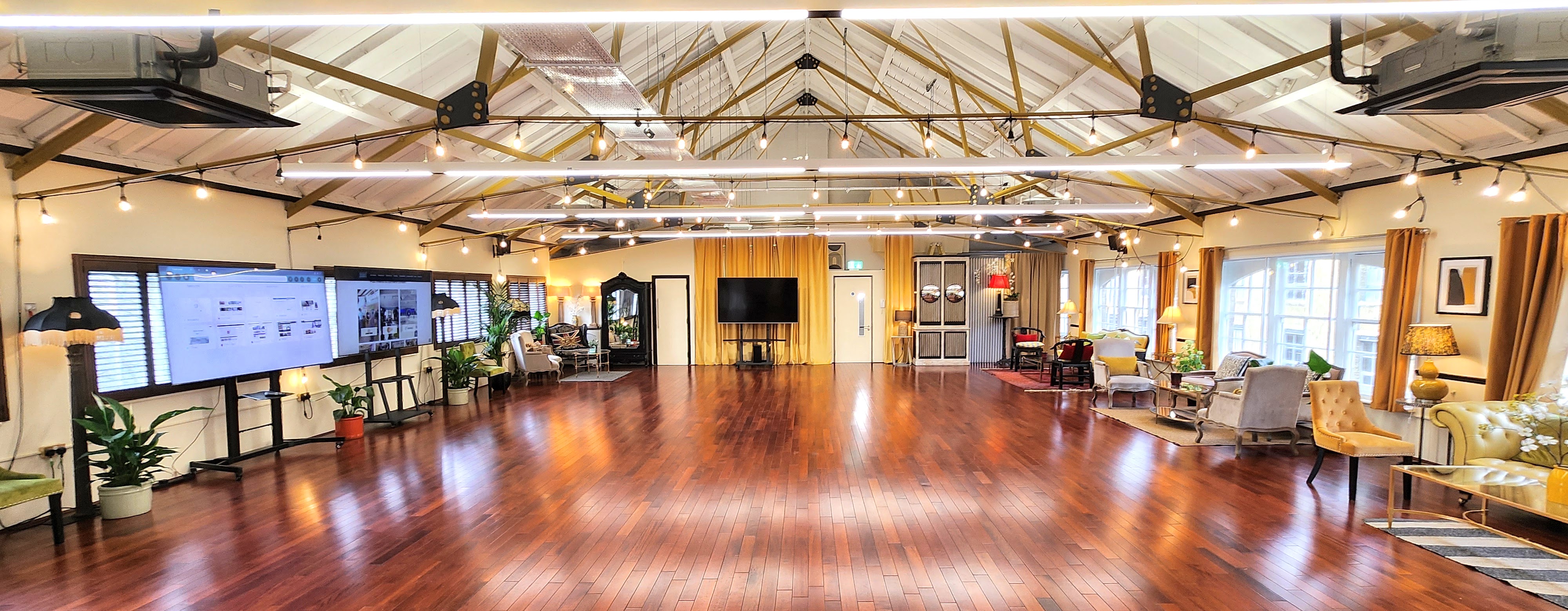 Spacious event space with wooden flooring for corporate events and celebrations. - Banner