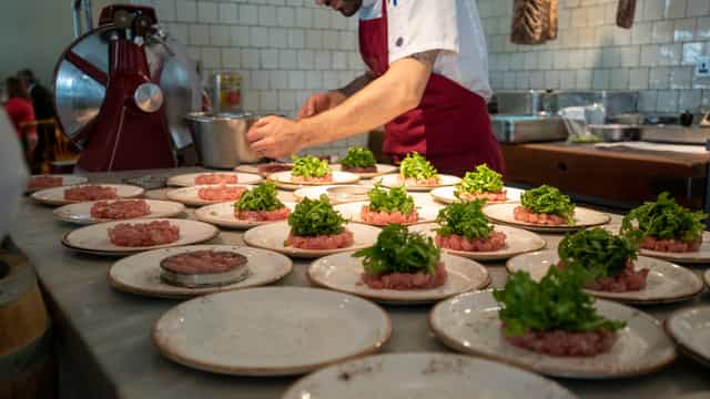 Culinary expert plating dishes at TOZI Restaurant for exclusive event catering.