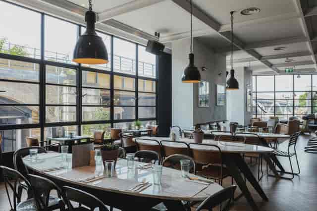 Modern restaurant venue with large windows, ideal for meetings and events.