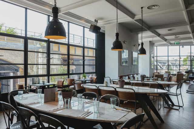 Modern restaurant venue with large windows, ideal for meetings and events.