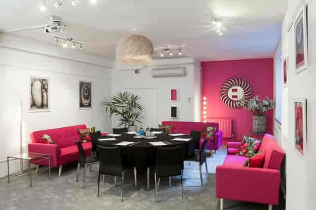 Circular boardroom and pink lounge seating for creative corporate workshops at London Art House.