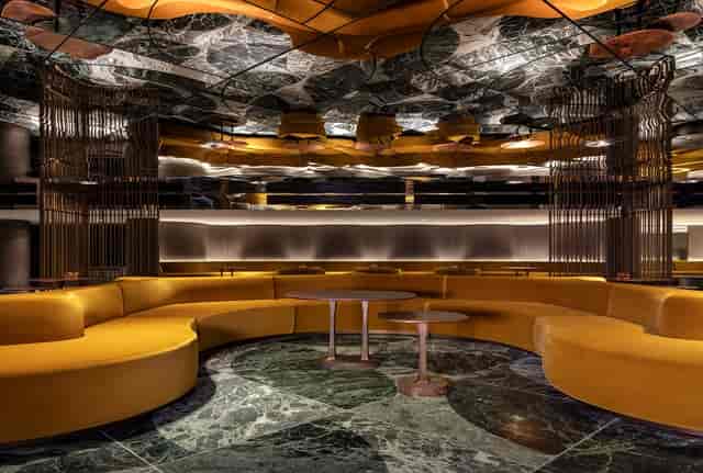 Elegant event space with curved seating and marble floor at The Londoner's Green Room.