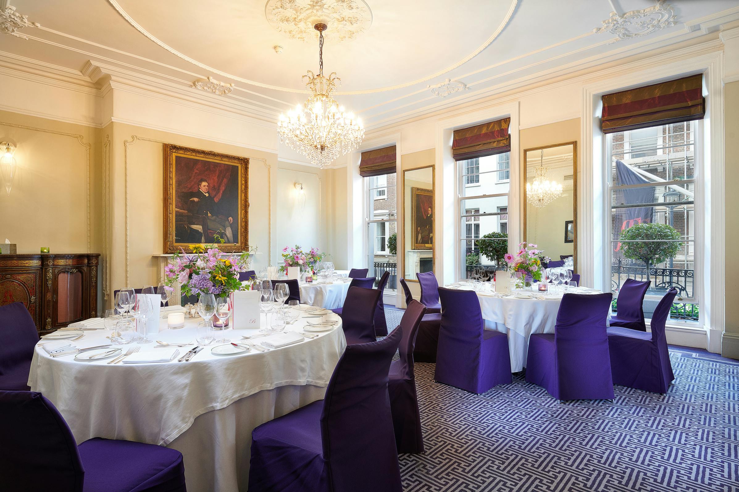 Elegant meeting space at Brown's Hotel with white linens and purple chair covers.
