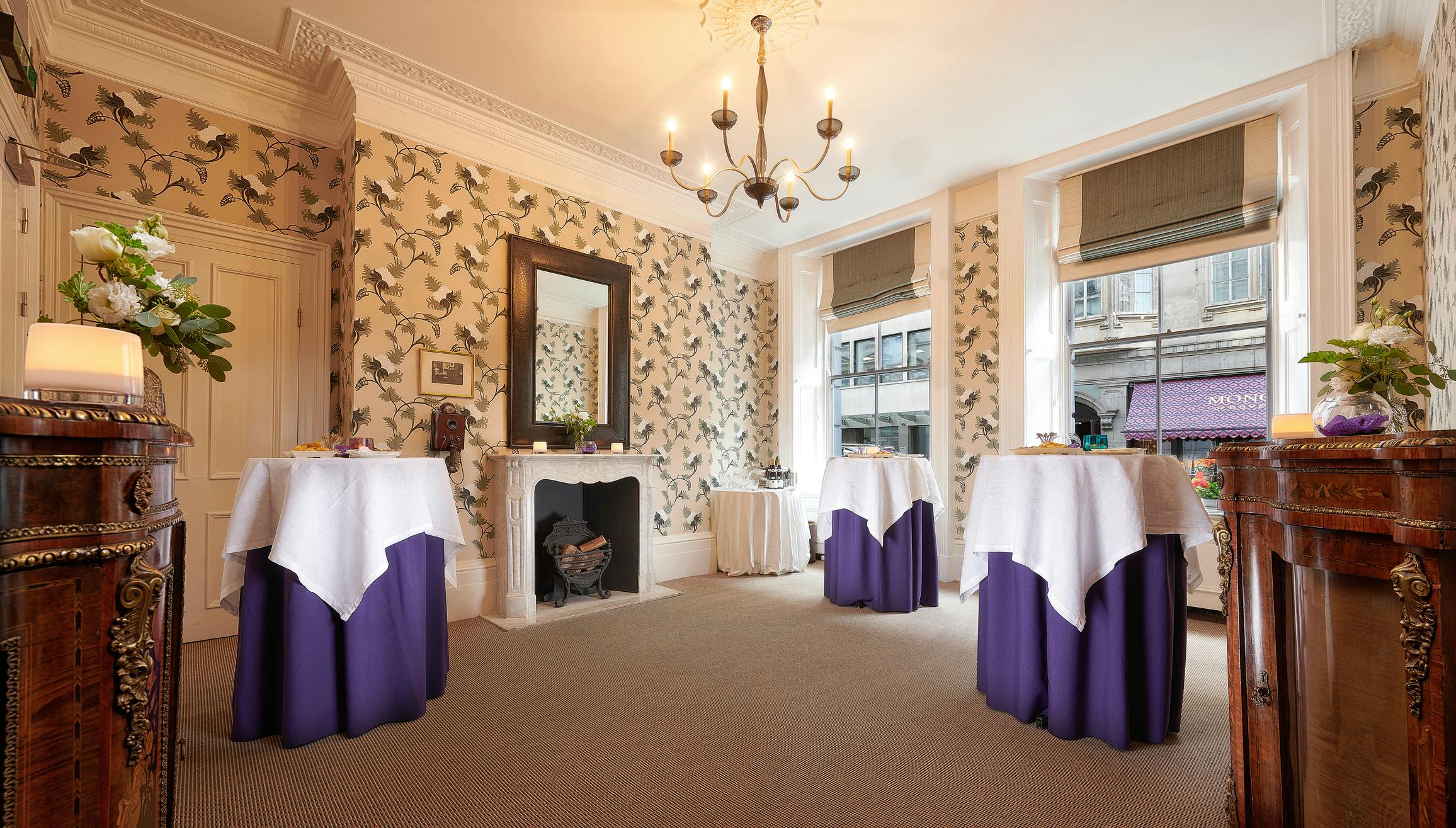 Graham Bell at Brown's Hotel, elegant event space with round tables and chandelier.