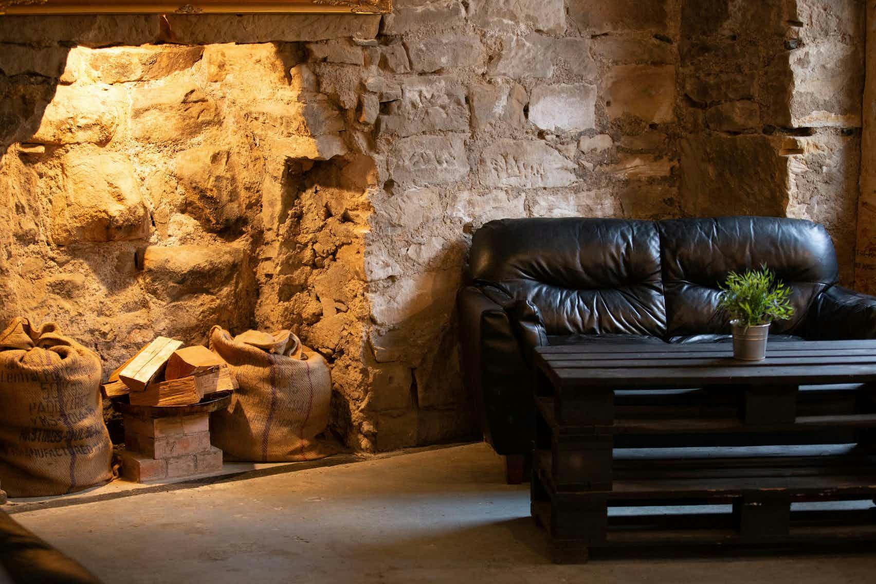 Cozy rustic meeting space with leather couch, ideal for team-building events.