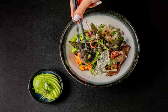 Vibrant catering bowl with fresh ingredients and avocado at Hijingo event.