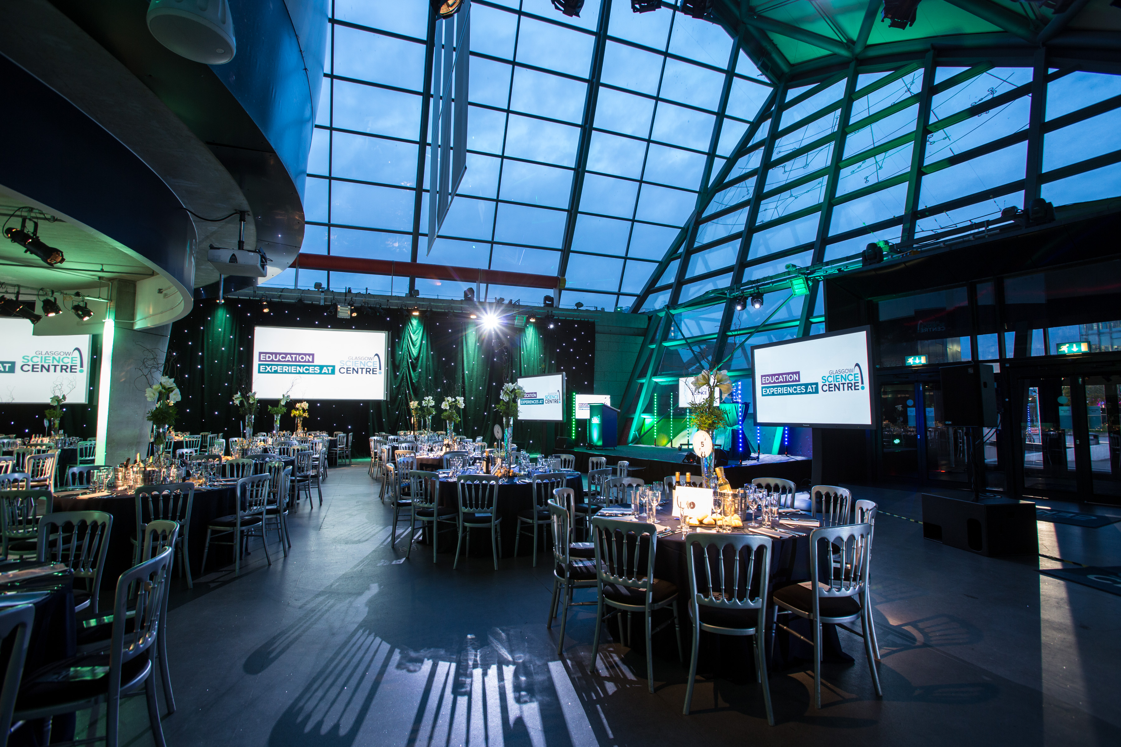 Atrium at Glasgow Science Centre: elegant event space with round tables, ideal for corporate galas. - Banner