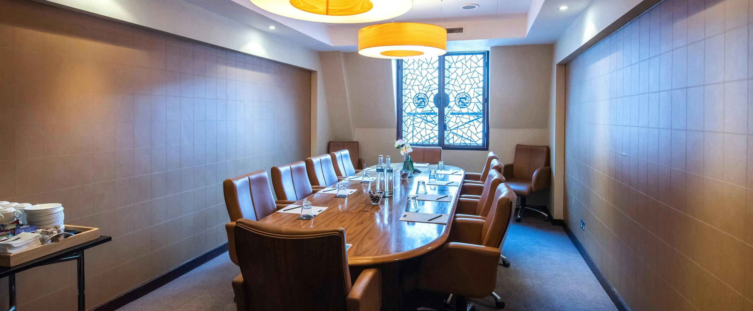 CUHK meeting room with wooden table and leather chairs for professional gatherings.