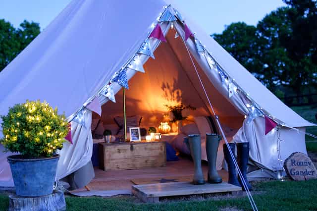 Cozy glamping tent with warm lighting for outdoor events and retreats.