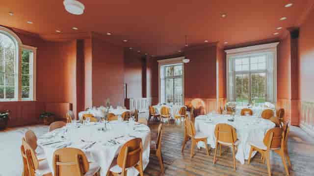 Elegant dining room with round tables, ideal for weddings and corporate events.